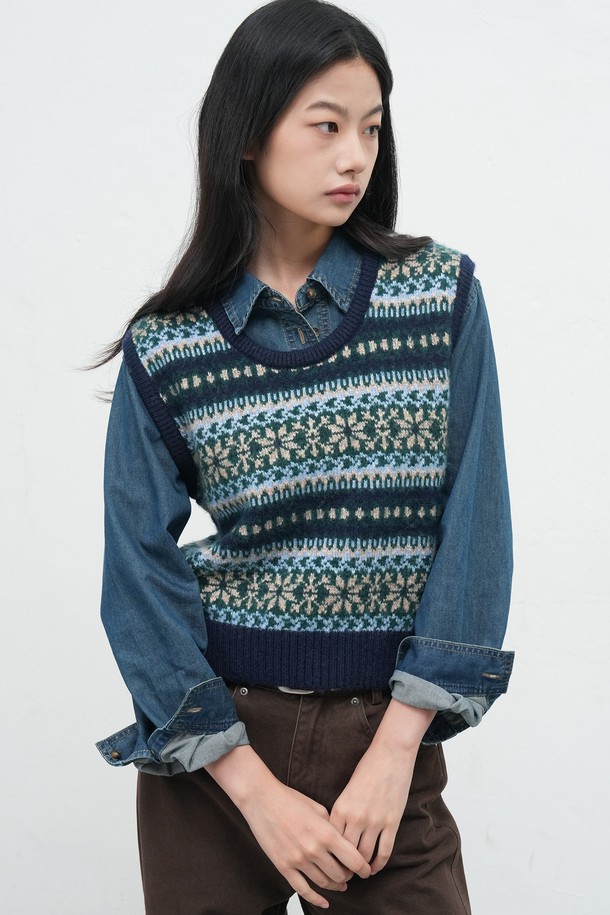 [25FW] WOMAN 페어아일 니트 베스트는 여성스러운 스타일을 완성하는 가을/겨울 시즌 필수 아이템입니다. 부드러운 울 소재와 두꺼운 두께감으로 포근하고 따뜻한 착용감을 선사합니다. 네이비, 블랙, 브라운의 세 가지 색상으로 출시되어 출근룩이나 모임룩 등 다양한 TPO에 활용 가능합니다. 페어아일 및 노르딕 패턴의 클래식한 디자인으로 캐주얼, 미니멀 스타일 모두 소화 가능하며, 레귤러핏 라운드넥 민소매 디자인으로 편안한 착용감을 제공합니다. 니트 조직 특유의 부드러운 촉감이 특징입니다.
