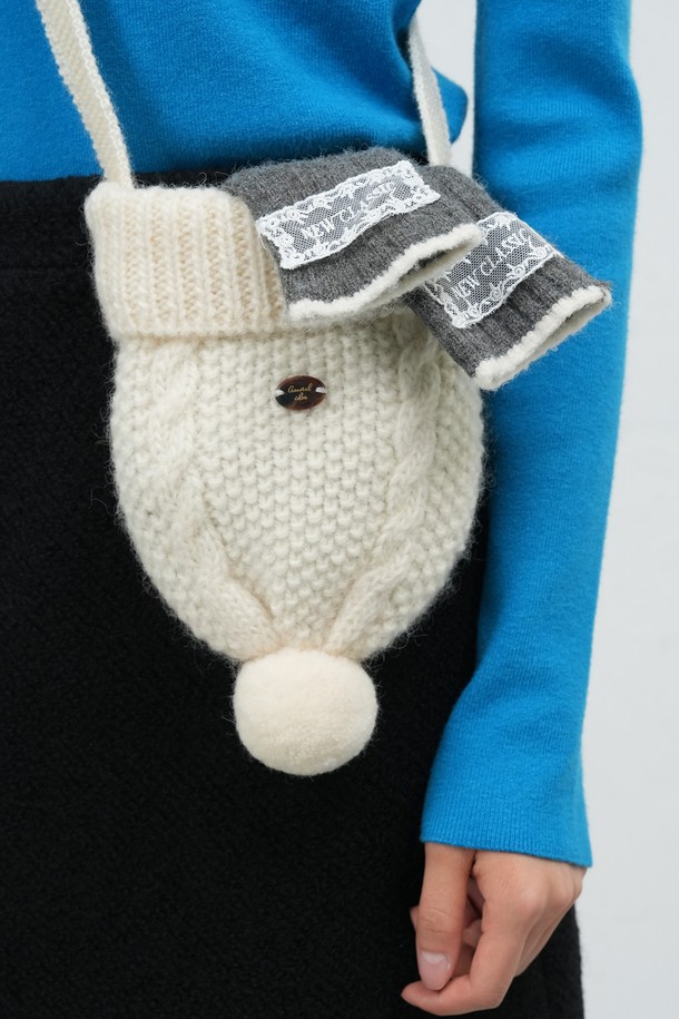 여성스러운 무드를 연출하는 [25FW] WOMAN 비니 니트 백입니다. 부드러운 니트 소재에 케이블 패턴을 더해 포근한 느낌을 주며, 폼폼과 리본 장식으로 걸리시한 분위기를 더했습니다. 크로스백 형태로 편안하게 착용 가능하며, 원형 디자인과 스몰 사이즈로 앙증맞은 매력을 선사합니다. 화이트, 그레이 컬러로 출시되어 다양한 데이트룩과 모임룩에 미니멀하게 포인트를 줄 수 있습니다. 겨울철 니트 소재 특유의 따뜻함과 사랑스러운 디자인이 돋보이는 아이템입니다.
