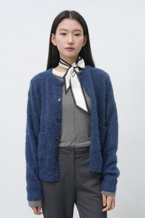 **[25FW] UNISEX 헤어리 니트 포켓 가디건**은 부드러운 울 소재로 제작되어 따뜻하고 포근한 착용감을 선사합니다. 가을과 겨울에 어울리는 두꺼운 두께감과 긴 소매 기장으로 보온성을 높였으며, 넉넉한 레귤러 핏으로 편안하게 착용할 수 있습니다. 캐주얼, 클래식, 미니멀 스타일을 모두 소화 가능하며, 무지 디자인과 네이비 컬러로 다양한 룩에 활용하기 좋습니다. 싱글 버튼 여밈과 포켓, 헤어리 텍스처 디테일이 돋보이며, 출근룩과 모임룩 등 TPO에 구애받지 않고 즐겨 입을 수 있습니다.
