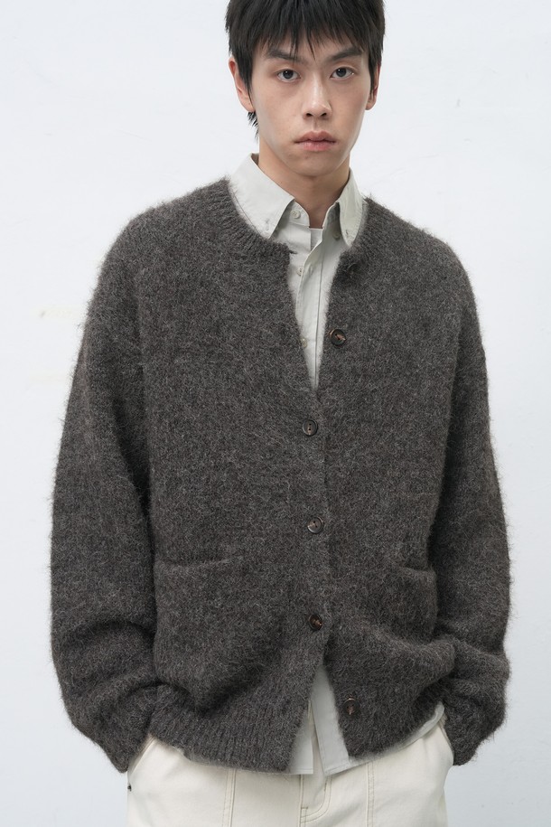 [25FW] MAN (맨) 울 블렌드 헤어리 루즈핏 가디건은 남성용 상의 가디건입니다. 부드러운 촉감의 울 소재로 제작되었으며, 가을과 겨울에 착용하기 좋은 두꺼운 두께감을 자랑합니다. 베이직하고 캐주얼한 스타일로, 무지 디자인과 넉넉한 루즈핏, 긴소매 기장으로 편안함을 더했습니다. 라운드넥에 버튼 여밈 방식이며, 헤어리한 질감이 특징입니다.
