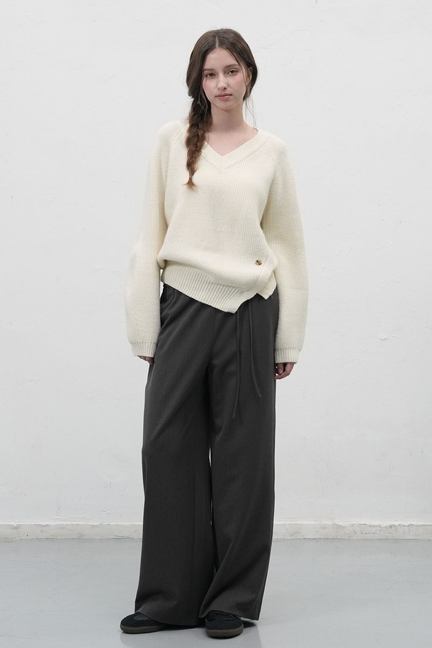 **[25FW] WOMAN 브이넥 슬릿 하찌 니트 풀오버 [3COL] /WBE3L05531**

부드러운 촉감의 여성용 브이넥 슬릿 하찌 니트 풀오버입니다. 가을과 겨울에 어울리는 두꺼운 두께감으로 따뜻하게 착용 가능하며, 루즈핏 디자인으로 편안한 착용감을 선사합니다. 아이보리, 차콜, 카키 3가지 색상으로 출시되었으며, 베이직한 스타일을 좋아하는 여성분들께 추천합니다. 비대칭 슬릿 디테일과 벌룬 소매, 하단 로고 디테일이 돋보이며, 신축성이 있어 활동성을 높였습니다. 겨울 데일리룩, 모임룩, 카페룩 등 다양한 TPO에 클래식, 미니멀, 캐주얼 스타일로 활용하기 좋습니다.
