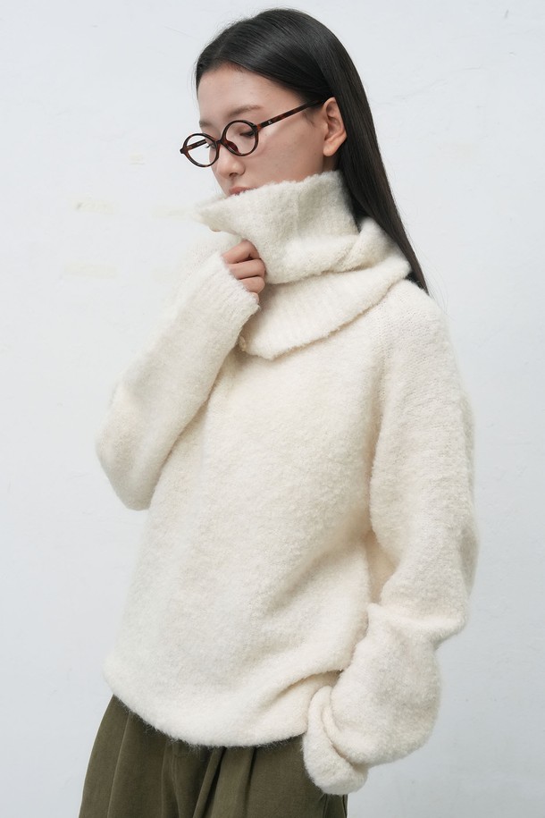 **[25FW] 우먼 넥 워머 루즈핏 부클 니트 [3COL] / WBE4L05550**

부드러운 부클 소재로 제작되어 포근한 착용감을 선사하는 여성용 넥 워머 루즈핏 니트입니다. 아이보리, 차콜, 올리브 세 가지 색상으로 출시되어 다양한 룩에 활용하기 좋습니다. 넥 워머 디자인과 루즈한 핏으로 편안하면서도 스타일리시하게 연출할 수 있으며, 가을, 겨울철 따뜻하게 입을 수 있는 두꺼운 두께감의 긴소매 니트입니다. 베이직하고 캐주얼한 스타일을 즐겨 입는 여성분들께 추천합니다. 특히 보온성이 뛰어나 추운 날씨에도 든든하게 몸을 감싸줍니다.
