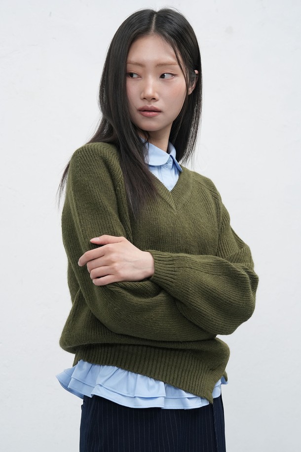 **[25FW] WOMAN 브이넥 슬릿 하찌 니트 풀오버 [3COL] /WBE3L05531**

여성스러운 무드를 연출하는 [25FW] WOMAN 브이넥 슬릿 하찌 니트 풀오버입니다. 아이보리, 차콜, 카키 3가지 색상으로 출시되었으며, 가을, 겨울 시즌에 적합합니다. 루즈핏으로 편안함을 선사하며, 두꺼운 두께감의 하찌 패턴이 포근함을 더합니다. 비대칭 슬릿 디테일과 벨 소매 디자인이 특징이며, 브랜드 로고 디테일로 포인트를 주었습니다. 베이직 스타일로 다양한 겨울 데일리룩, 모임룩, 카페룩에 활용하기 좋습니다.
