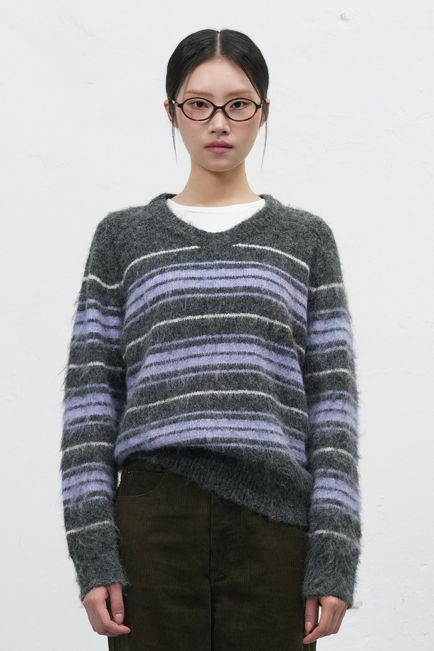 [25FW] WOMAN 헤어리 스트라이프 루즈 풀오버는 부드러운 헤어리 촉감과 브이넥 디자인이 돋보이는 여성용 니트 스웨터입니다. 가을, 겨울 시즌에 적합하며, 울 혼방 소재로 제작되어 따뜻하고 포근한 착용감을 선사합니다. 

레드 브라운, 차콜 두 가지 색상으로 출시되었으며, 루즈핏과 긴 소매 기장으로 편안한 캐주얼 스타일을 연출합니다. 브러시 가공과 새들 숄더 디자인이 특징이며, 스트라이프 패턴이 세련된 포인트를 더합니다. 

일상, 카페, 모임 등 다양한 TPO에 활용할 수 있으며, 캐주얼, 클래식, 미니멀 스타일을 즐기는 여성에게 추천합니다. 
