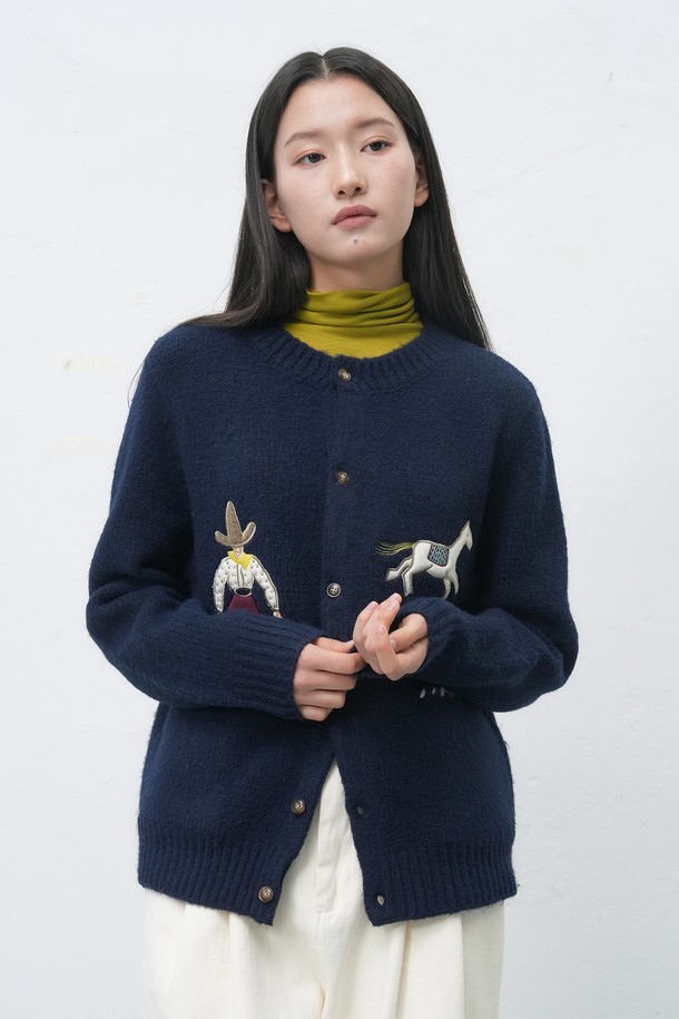 "[25FW] UNISEX 카우보이 크루넥 가디건 [4COL] / SBE4U04013"는 일상에서 편안하게 착용하기 좋은 유니섹스 가디건입니다. 가을과 겨울에 어울리는 두꺼운 두께감과 부드러운 니트 소재로 제작되어 따뜻하고 포근한 착용감을 선사합니다. 크루넥 디자인과 레귤러핏으로 제작되었으며, 캐주얼 스타일을 연출하기 좋습니다. 네이비 컬러를 바탕으로, 카우보이 모티프 자수 디테일이 돋보이는 디자인으로 포인트를 더했습니다. 긴 소매 기장과 레귤러 기장으로 다양한 스타일링에 활용하기 좋습니다.
