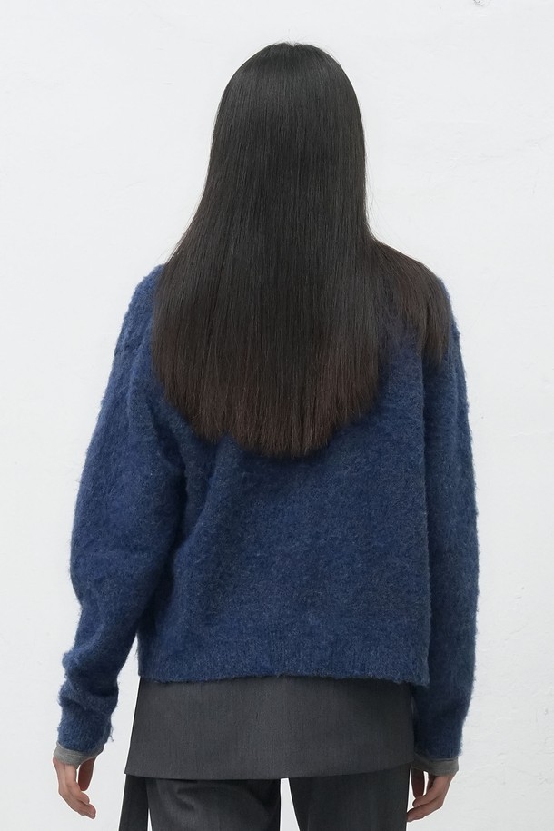 **[25FW] UNISEX 헤어리 니트 포켓 가디건**은 부드러운 울 소재로 제작되어 따뜻하고 포근한 착용감을 선사합니다. 가을과 겨울에 어울리는 두꺼운 두께감과 긴 소매 기장으로 보온성을 높였으며, 넉넉한 레귤러 핏으로 편안하게 착용할 수 있습니다. 캐주얼, 클래식, 미니멀 스타일을 모두 소화 가능하며, 무지 디자인과 네이비 컬러로 다양한 룩에 활용하기 좋습니다. 싱글 버튼 여밈과 포켓, 헤어리 텍스처 디테일이 돋보이며, 출근룩과 모임룩 등 TPO에 구애받지 않고 즐겨 입을 수 있습니다.
