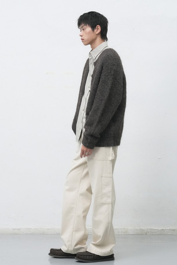[25FW] MAN (맨) 울 블렌드 헤어리 루즈핏 가디건은 남성용 상의 가디건입니다. 부드러운 촉감의 울 소재로 제작되었으며, 가을과 겨울에 착용하기 좋은 두꺼운 두께감을 자랑합니다. 베이직하고 캐주얼한 스타일로, 무지 디자인과 넉넉한 루즈핏, 긴소매 기장으로 편안함을 더했습니다. 라운드넥에 버튼 여밈 방식이며, 헤어리한 질감이 특징입니다.
