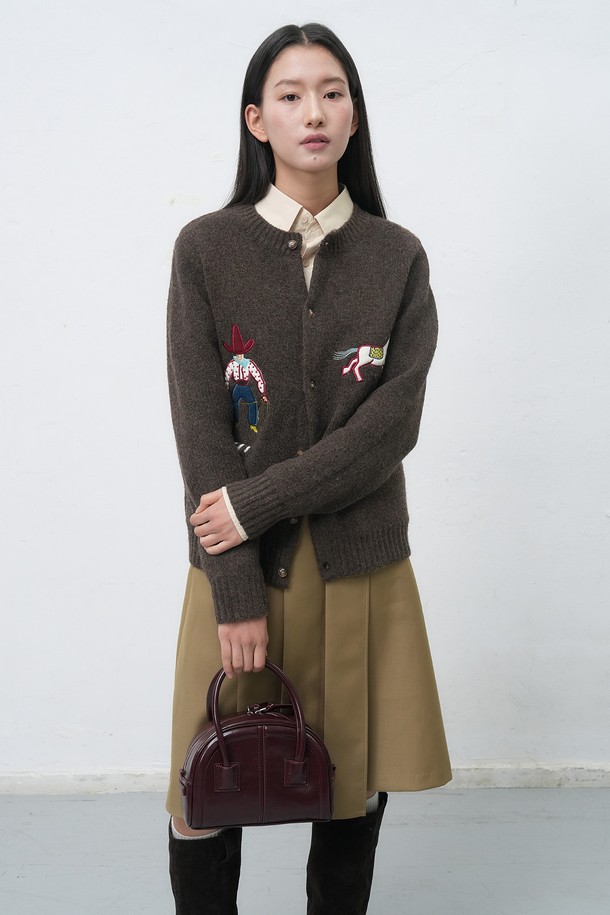 **[25FW] UNISEX 카우보이 크루넥 가디건 [4COL] / SBE4U04013**

이번 시즌, 캐주얼하고 클래식한 스타일을 연출할 수 있는 유니섹스 카우보이 크루넥 가디건입니다. 부드러운 울 소재로 제작되어 가을과 겨울에 따뜻하게 착용할 수 있으며, 두께감이 있어 포근한 착용감을 선사합니다. 크루넥 디자인과 레귤러 핏으로 편안하게 착용 가능하며, 카우보이 모티프 자수 패턴이 돋보이는 디자인입니다. 네이비, 브라운 두 가지 컬러로 출시되어 다양한 스타일 연출에 활용할 수 있습니다. 긴 소매 기장의 레귤러핏 가디건으로 데일리룩에 포인트 아이템으로 활용해보세요.
