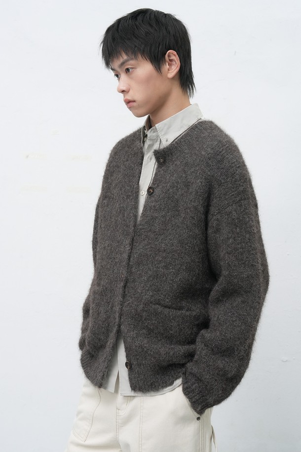 [25FW] MAN (맨) 울 블렌드 헤어리 루즈핏 가디건은 남성용 상의 가디건입니다. 부드러운 촉감의 울 소재로 제작되었으며, 가을과 겨울에 착용하기 좋은 두꺼운 두께감을 자랑합니다. 베이직하고 캐주얼한 스타일로, 무지 디자인과 넉넉한 루즈핏, 긴소매 기장으로 편안함을 더했습니다. 라운드넥에 버튼 여밈 방식이며, 헤어리한 질감이 특징입니다.
