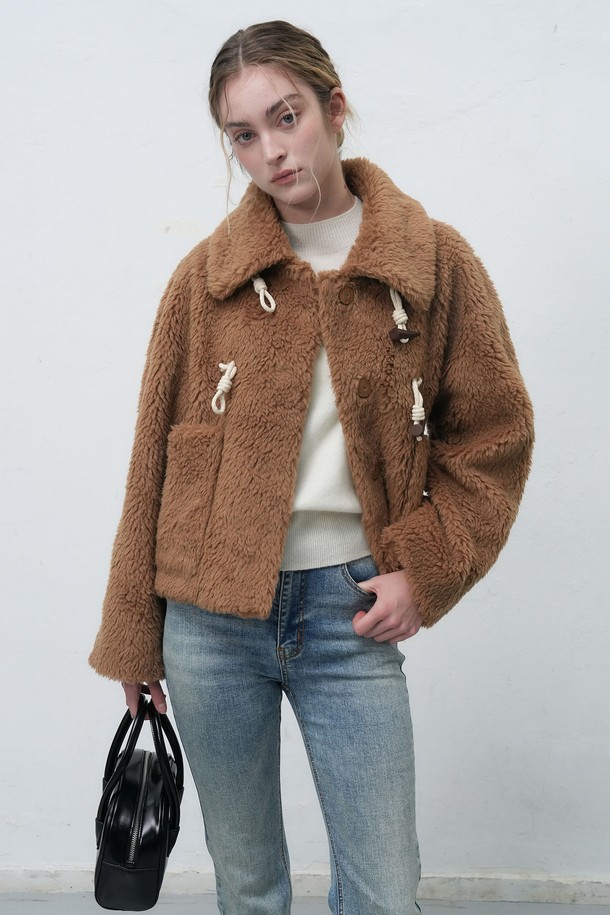 "[25FW] WOMAN 울 블렌드 페이크 퍼 더플 재킷"은 여성용 아우터로, 가을과 겨울에 착용하기 좋은 두꺼운 두께감의 더플 코트입니다. 캐주얼 및 베이직 스타일을 기반으로 하며, 아이보리 및 브라운 두 가지 색상으로 제공됩니다. 울과 페이크 퍼 소재를 사용하여 부드러운 촉감을 선사하며, 긴 소매와 레귤러 핏으로 편안한 착용감을 제공합니다. 토글 여밈 방식과 퍼 카라 디테일이 돋보이는 디자인으로, 일상에서 폭넓게 활용할 수 있습니다.
