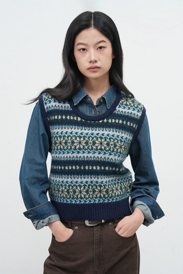 [25FW] WOMAN 페어아일 니트 베스트는 여성스러운 스타일을 완성하는 가을/겨울 시즌 필수 아이템입니다. 부드러운 울 소재와 두꺼운 두께감으로 포근하고 따뜻한 착용감을 선사합니다. 네이비, 블랙, 브라운의 세 가지 색상으로 출시되어 출근룩이나 모임룩 등 다양한 TPO에 활용 가능합니다. 페어아일 및 노르딕 패턴의 클래식한 디자인으로 캐주얼, 미니멀 스타일 모두 소화 가능하며, 레귤러핏 라운드넥 민소매 디자인으로 편안한 착용감을 제공합니다. 니트 조직 특유의 부드러운 촉감이 특징입니다.
