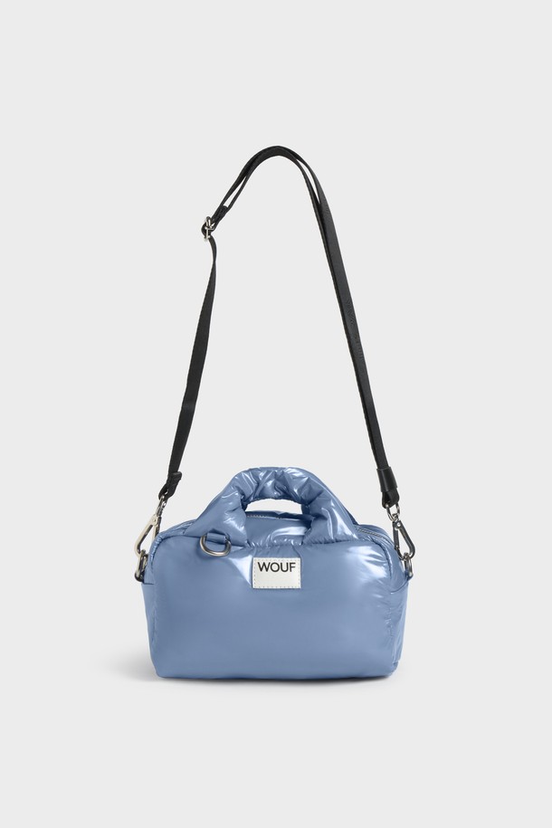 WO 글로시 로얄 볼링백은 세련된 여성스러움을 강조하는 미디엄 사이즈의 원통형 볼링백입니다. 방수 기능을 갖춘 이 가방은 폴리에스테르와 가죽 소재로 제작되었으며, 블루 컬러의 무지 디자인에 광택감 있는 외관이 특징입니다. YKK 지퍼와 탈부착 가능한 최대 110cm 길이의 조절 가능한 숄더 스트랩이 있어 실용성을 더하며, 내부 포켓과 패딩 핸들로 편안한 사용감을 제공합니다. 재활용 소재를 사용하여 제작되었으며, WR 코팅으로 생활 방수 기능을 강화했습니다. 여행, 휴가, 산책 등 다양한 TPO에 미니멀, 클래식, 캐주얼 스타일로 연출하기 좋습니다.