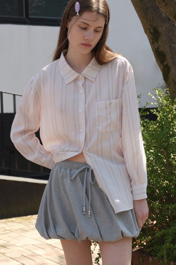 [25MID CAPSULE]의 OBLIQUE BALLOON SKIRT는 멜란지 색상의 여성용 벌룬 미니스커트입니다. 사선 플리츠 디자인과 허리 실버볼 포인트가 특징이며, 밴딩 허리밴드로 편안함을 더했습니다. 면과 폴리에스테르 혼방 소재로 제작되었으며, 봄, 여름에 일상복으로 착용하기 좋은 미니멀 스타일의 아이템입니다.
