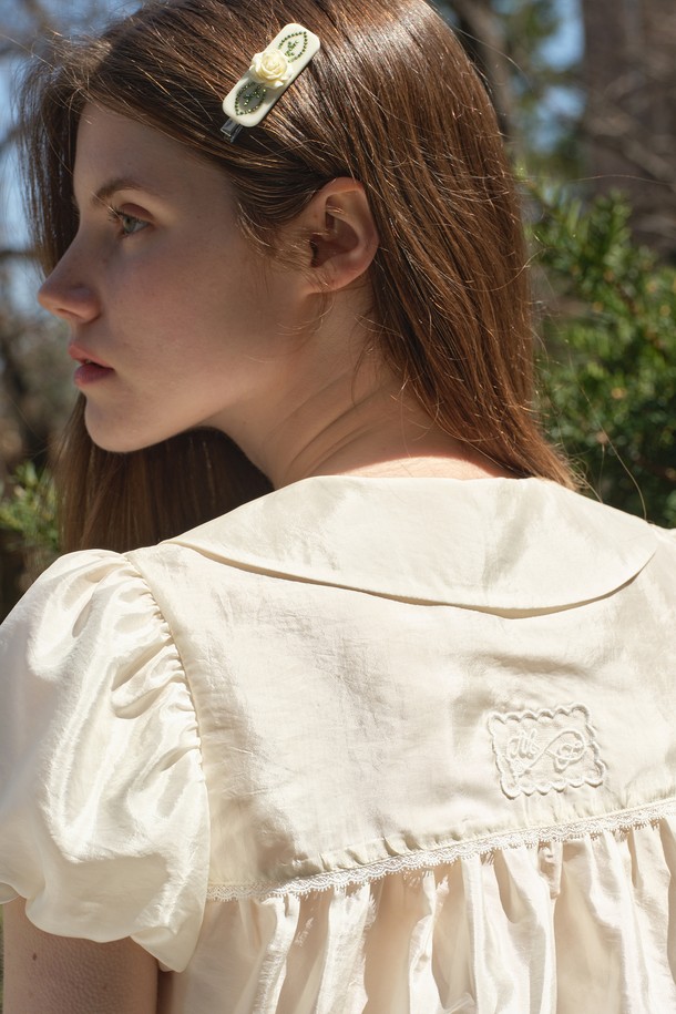 [25MID CAPSULE] ROSE 핫픽스 헤어핀은 크림색 아크릴과 니켈 소재로 제작되었으며, 로즈 모티프와 핫픽스, 리프 디자인 장식이 돋보입니다. 가로 7cm, 세로 1.2cm 크기의 클립형 헤어핀으로, 뒷면에는 로고 인그레이빙이 더해졌으며 오간자 파우치가 함께 제공됩니다. 수공예 마감으로 제작되었으며, 핫픽스 요소 탈락 및 외부 압력이나 마찰에 의한 스크래치 발생에 유의하여 사용하시기 바랍니다.
