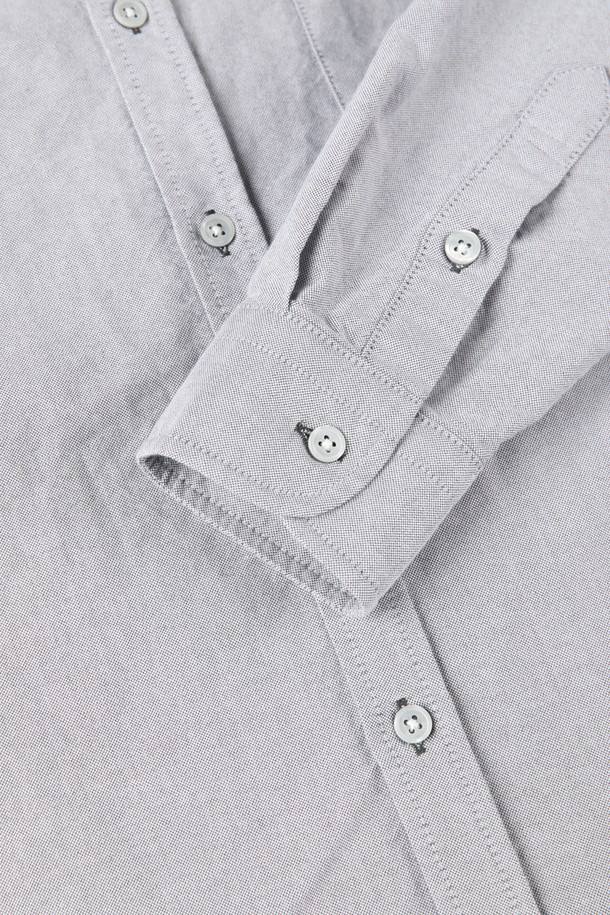 **코튼 옥스포드 셔츠 D-GCSH64**는 남성용 옥스포드 셔츠입니다. 베이직하고 클래식한 스타일로, 여름과 간절기에 착용하기 좋습니다. 슬림핏으로 제작되었으며, 그레이와 화이트 두 가지 색상으로 출시되었습니다. 싱글 체스트 포켓과 버튼 클로저, P 자수 로고가 특징이며, 출근룩, 비즈니스 캐주얼, 오피스룩에 적합합니다. 미니멀하고 클래식한 스타일을 연출할 수 있는 아이템입니다.
