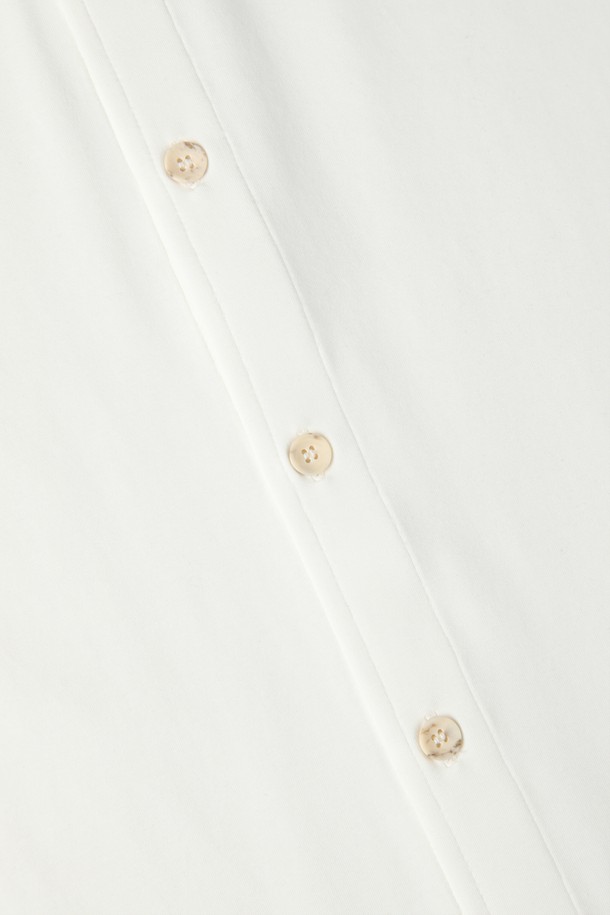 아이보리 컬러의 남성용 반소매 저지 셔츠 D-QCSH04입니다. 면, 레이온, 스판 혼방 소재로 제작되어 부드러운 촉감을 선사하며, 레귤러핏과 슬림핏으로 다양한 스타일 연출이 가능합니다. 칼라 네크라인과 밑단 로고 자수 디테일, 단추 여밈이 특징이며, 단독 착용은 물론 아우터와 레이어드하여 캐주얼, 미니멀, 클래식 스타일을 소화하기 좋습니다. 데이트룩, 카페룩과 같은 TPO에 적합하며, 여름, 간절기, 겨울까지 활용 가능한 활용도 높은 아이템입니다.
