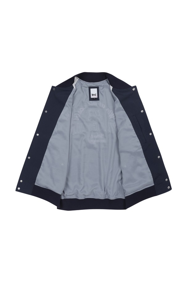 네이비와 화이트 컬러 배색이 돋보이는 남성 바시티 재킷입니다. 봄, 가을 시즌에 골프, 일상 등 다양한 TPO에 캐주얼, 스트릿, 미니멀 스타일로 활용하기 좋습니다. 레귤러핏에 보통 두께감으로 제작되었으며, 드라이한 촉감의 스판 소재를 사용하여 편안한 착용감을 선사합니다. 목 부분과 밑단 스트라이프 립 디테일, 자수 와펜 장식이 포인트이며, 긴 소매와 버튼 여밈 방식으로 디자인되었습니다.
