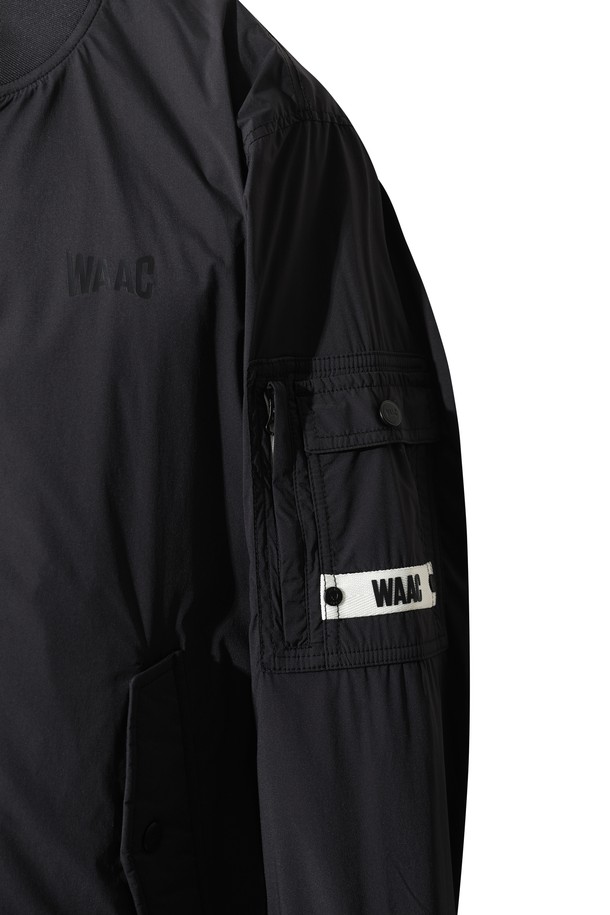 블랙 색상의 패디드 봄버 자켓입니다. 남성용으로, 골프 및 일상복으로 활용하기 좋습니다. 나일론과 스판덱스 혼방 소재로 제작되어 부드러운 촉감과 신축성을 제공하며, 두꺼운 두께감으로 겨울철 보온성을 높여줍니다. 경량 패딩 안감과 니트 시보리 디테일이 특징이며, 레귤러 핏과 긴 소매 기장, 집업 여밈 방식으로 편안한 착용감을 선사합니다. 캐주얼, 스포티, 미니멀 스타일을 모두 소화할 수 있는 활용도 높은 아우터입니다.
