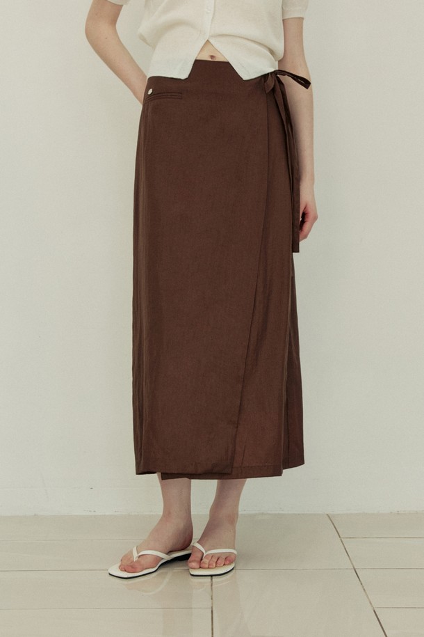 립 포켓 H 라인 랩 스커트 - 브라운은 여성스러운 무드를 연출하는 H라인 스커트입니다. 얇고 부드러운 나일론 소재로 제작되어 여름에도 시원하게 착용 가능하며, 슬림핏 디자인으로 다리 라인을 더욱 돋보이게 합니다. 랩 스타일로 사이드 타이 디테일이 특징이며, 비침 걱정 없이 레이어드하여 다양한 스타일을 연출할 수 있습니다. 데이트룩, 카페룩, 모임룩 등 TPO에 구애받지 않고 클래식하면서 미니멀한 스타일을 완성할 수 있습니다.
