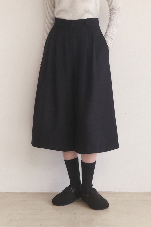 울 소재의 핀턱 롱 버뮤다 팬츠 - 블랙입니다. 미니멀하고 클래식한 스타일을 추구하는 여성분들을 위한 5부 기장의 바지입니다. 핀턱 디테일이 돋보이며, 루즈핏으로 편안하게 착용 가능합니다. 봄, 가을 시즌에 적합하며, 두꺼운 울 소재로 제작되어 뻣뻣한 촉감을 줍니다. 오피스룩, 비즈니스 캐주얼, 모임룩 등 다양한 TPO에 활용할 수 있는 시크한 아이템입니다.
