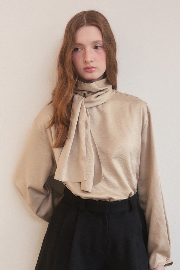 베이지 색상의 새틴 사이드 버튼 스카프 넥 블라우스는 우아하고 엘레강스한 스타일을 연출합니다. 릴랙스핏으로 편안함을 더했으며, 폴리에스테르와 나일론 혼방 소재로 부드러운 촉감을 선사합니다. 긴 소매와 중간 두께감으로 겨울철에도 따뜻하게 착용할 수 있으며, 오피스룩, 모임룩, 소개팅룩 등 다양한 TPO에 활용 가능합니다. 어깨 버튼 장식과 스카프 넥라인의 리본 디테일이 돋보이며, 오프숄더 스타일링도 가능하여 클래식, 미니멀, 로맨틱 무드를 모두 만족시키는 아이템입니다.
