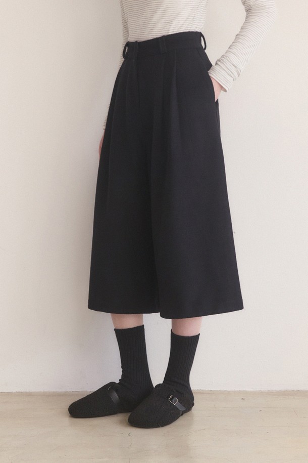 울 소재의 핀턱 롱 버뮤다 팬츠 - 블랙입니다. 미니멀하고 클래식한 스타일을 추구하는 여성분들을 위한 5부 기장의 바지입니다. 핀턱 디테일이 돋보이며, 루즈핏으로 편안하게 착용 가능합니다. 봄, 가을 시즌에 적합하며, 두꺼운 울 소재로 제작되어 뻣뻣한 촉감을 줍니다. 오피스룩, 비즈니스 캐주얼, 모임룩 등 다양한 TPO에 활용할 수 있는 시크한 아이템입니다.
