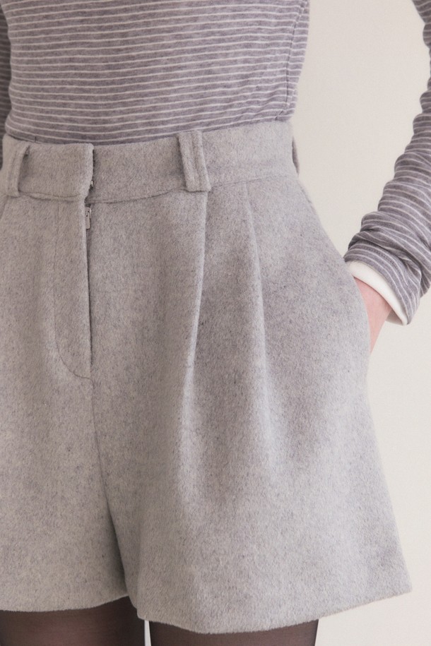 라이트 그레이 색상의 울 핀턱 숏팬츠입니다. 여성용으로, 겨울에 어울리는 두꺼운 두께감과 부드러운 촉감이 특징입니다. 슬림 핏으로 우아하고 클래식한 스타일을 연출하며, 하이웨스트 디자인으로 다리가 길어 보이는 효과를 줍니다. 핀턱 디테일과 힙라인의 여유로운 실루엣, 포켓 디테일이 돋보입니다. 오피스룩, 모임룩, 소개팅룩 등 다양한 TPO에 미니멀하고 시크하게 매치할 수 있습니다.
