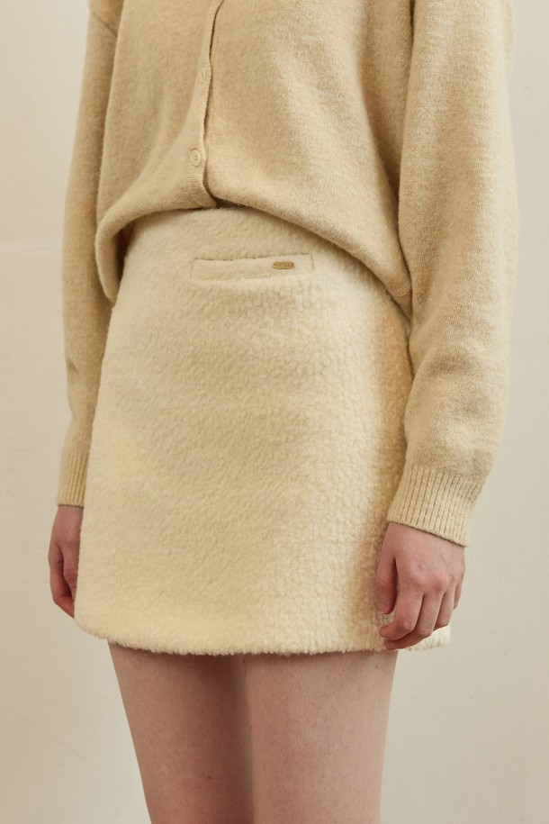 아이보리 색상의 테디 부클 트위드 미니 스커트입니다. 부드러운 촉감의 테디 부클 소재와 두꺼운 두께로 가을, 겨울 시즌에 따뜻하게 착용하기 좋습니다. 클래식하고 우아한 스타일을 연출하며, A라인 핏으로 다리가 길어 보이는 효과를 줍니다. 데이트룩, 모임룩, 소개팅룩 등 다양한 TPO에 활용하기 좋으며, 미니멀한 스타일을 즐기는 분들께 추천합니다. 무지 디자인으로 어떤 상의와도 쉽게 매치할 수 있어 활용도가 높습니다.
