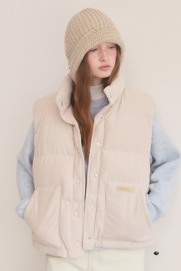 따뜻하고 부드러운 코듀로이 소재의 오버핏 패딩 베스트입니다. 베이직한 디자인에 크롭 기장과 퀄팅 디테일로 포인트를 주어 캐주얼하면서도 스타일리시한 연출이 가능합니다. 가을, 겨울 시즌에 활용하기 좋은 두꺼운 두께감으로 보온성을 높였으며, 부드러운 촉감과 민소매 디자인으로 편안한 착용감을 선사합니다. 베이지, 블랙 두 가지 컬러로 출시되어 다양한 룩에 매치하기 용이하며, 버튼 여밈 방식으로 간편하게 착용할 수 있습니다. 여성스러운 스타일을 더욱 돋보이게 해주는 아이템입니다.
