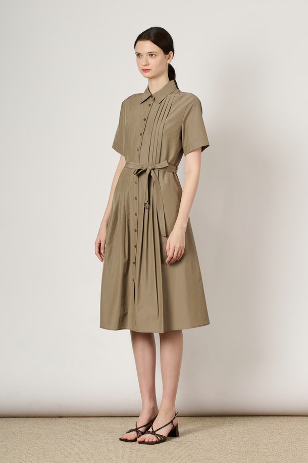 [24SU] 핀턱 셔츠 원피스는 다크 베이지 색상의 여성용 셔츠 원피스로, 면과 폴리에스터 혼방 소재로 제작되어 여름철 데일리룩으로 적합합니다. 상단의 핀턱 디테일과 벨트 구성이 특징이며, 슬림핏 실루엣과 자연스럽게 퍼지는 밑단이 돋보입니다. 안감이 있어 편안하게 착용 가능하며, 베이직하고 클래식한 무드를 연출할 수 있는 무지 패턴의 반소매 셔츠 원피스입니다.
