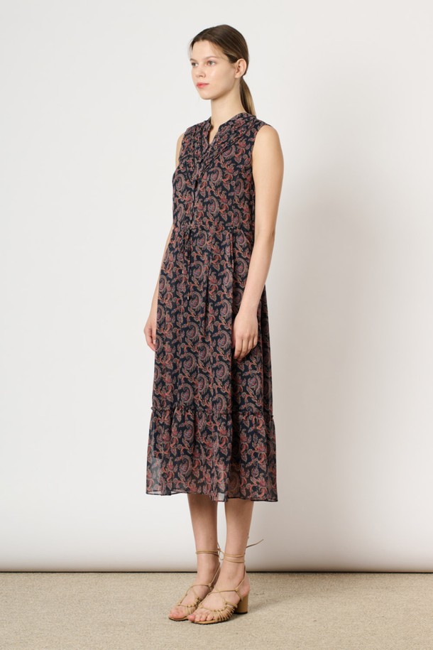 [24SU] 링클 페이즐리 프린트 원피스는 네이비 색상의 여성용 민소매 원피스입니다. 폴리에스터 소재로 제작되었으며, 링클 소재 특유의 시원한 착용감과 부드러운 촉감이 특징입니다. 브이넥 디자인에 프론트 핀턱 디테일과 밑단 플레어 디자인이 더해져 우아하고 페미닌한 무드를 연출하며, 페이즐리 프린트가 돋보이는 여름 일상복입니다.
