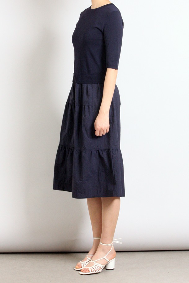 네이비 컬러의 여성용 반소매 스커트 세트 원피스입니다. 봄, 여름 시즌에 어울리는 얇은 두께의 캐주얼 스타일로, 라운드넥과 루즈핏 A라인 실루엣이 편안한 착용감을 선사합니다. 티어드 치마 타입에 무지 패턴으로 디자인되었으며, 실용적인 포켓 디테일을 더했습니다.
