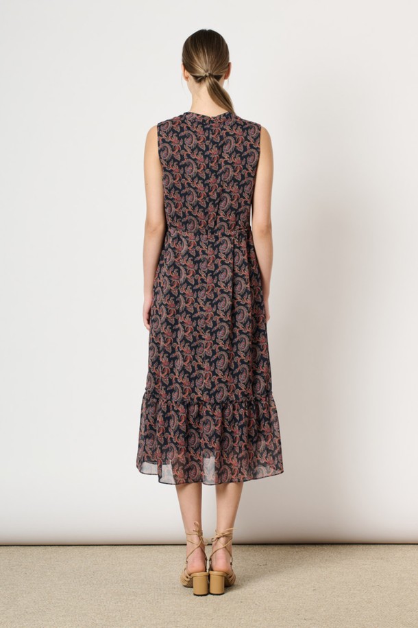 [24SU] 링클 페이즐리 프린트 원피스는 네이비 색상의 여성용 민소매 원피스입니다. 폴리에스터 소재로 제작되었으며, 링클 소재 특유의 시원한 착용감과 부드러운 촉감이 특징입니다. 브이넥 디자인에 프론트 핀턱 디테일과 밑단 플레어 디자인이 더해져 우아하고 페미닌한 무드를 연출하며, 페이즐리 프린트가 돋보이는 여름 일상복입니다.
