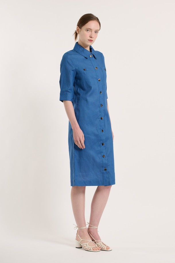 [25SU] 린넨 블렌드 원피스 - ROYAL BLUE B5M3G67057는 린넨과 면 혼방 소재로 제작되어 여름철에도 시원하고 쾌적하게 착용할 수 있는 여성용 7부 소매 원피스입니다. 로얄 블루 색상의 무지 패턴 디자인이 특징이며, 셔츠 칼라와 버튼 디테일, 포켓 디테일이 더해져 클래식하면서도 엘레강스한 무드를 연출합니다. 얇고 부드러운 촉감의 이 레귤러핏 원피스는 이중 소재 구성으로 착용감을 높였으며, 일상 생활에서 편안하게 입을 수 있습니다.
