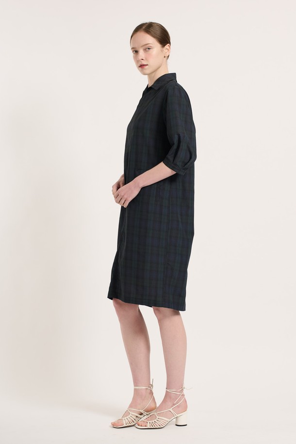 [25SU] 타탄 체크 원피스 - NAVY는 네이비 컬러의 클래식한 무드를 담은 여성용 7부 타탄 체크 원피스입니다. 폴리에스터, 나일론, 면 혼방 소재로 제작되었으며, 여유로운 핏과 소매 턱 디테일, 인 포켓 디자인이 특징입니다. 뒤 지퍼 클로징으로 편안하게 착용 가능하며, 일상복으로 좋은 여름 시즌 아이템입니다.
