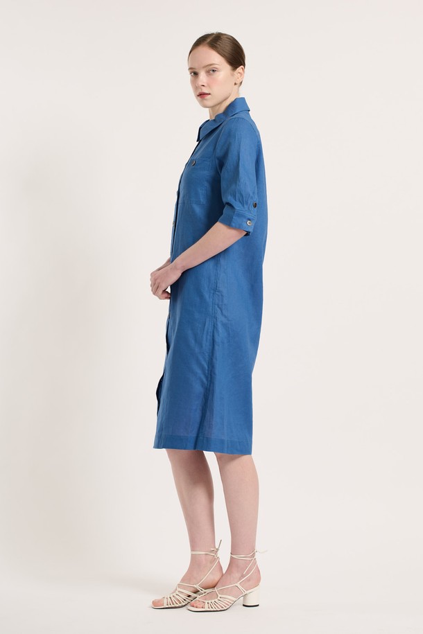 [25SU] 린넨 블렌드 원피스 - ROYAL BLUE B5M3G67057는 린넨과 면 혼방 소재로 제작되어 여름철에도 시원하고 쾌적하게 착용할 수 있는 여성용 7부 소매 원피스입니다. 로얄 블루 색상의 무지 패턴 디자인이 특징이며, 셔츠 칼라와 버튼 디테일, 포켓 디테일이 더해져 클래식하면서도 엘레강스한 무드를 연출합니다. 얇고 부드러운 촉감의 이 레귤러핏 원피스는 이중 소재 구성으로 착용감을 높였으며, 일상 생활에서 편안하게 입을 수 있습니다.
