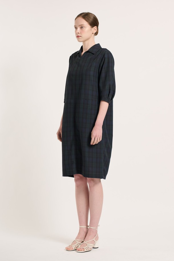 [25SU] 타탄 체크 원피스 - NAVY는 네이비 컬러의 클래식한 무드를 담은 여성용 7부 타탄 체크 원피스입니다. 폴리에스터, 나일론, 면 혼방 소재로 제작되었으며, 여유로운 핏과 소매 턱 디테일, 인 포켓 디자인이 특징입니다. 뒤 지퍼 클로징으로 편안하게 착용 가능하며, 일상복으로 좋은 여름 시즌 아이템입니다.
