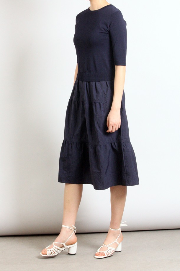 네이비 컬러의 여성용 반소매 스커트 세트 원피스입니다. 봄, 여름 시즌에 어울리는 얇은 두께의 캐주얼 스타일로, 라운드넥과 루즈핏 A라인 실루엣이 편안한 착용감을 선사합니다. 티어드 치마 타입에 무지 패턴으로 디자인되었으며, 실용적인 포켓 디테일을 더했습니다.
