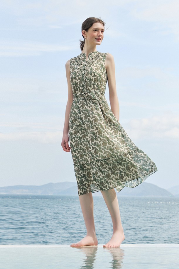 [24SU] 링클 페이즐리 프린트 원피스는 네이비 색상의 여성용 민소매 원피스입니다. 폴리에스터 소재로 제작되었으며, 링클 소재 특유의 시원한 착용감과 부드러운 촉감이 특징입니다. 브이넥 디자인에 프론트 핀턱 디테일과 밑단 플레어 디자인이 더해져 우아하고 페미닌한 무드를 연출하며, 페이즐리 프린트가 돋보이는 여름 일상복입니다.
