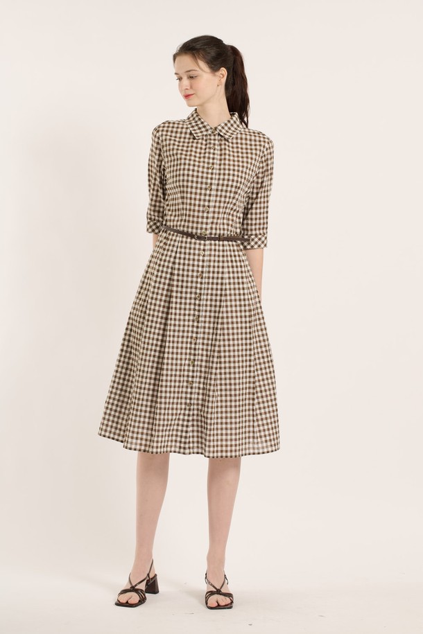 [25SU] 깅엄원피스는 브라운 색상의 체크 패턴이 돋보이는 여성용 깅엄 원피스입니다. 면, 폴리우레탄, 코튼 혼방 소재로 제작되었으며, 7부 소매와 플리츠 스커트 디자인이 특징입니다. 허리 벨트가 포함되어 슬림한 실루엣을 연출할 수 있으며, 칼라 네크라인과 버튼다운 디자인으로 클래식하면서도 엘레강스한 무드를 선사합니다.
