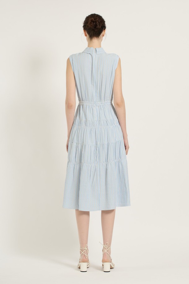 [25SU] 스트라이프 티어드 원피스는 스카이 블루 색상의 스트라이프 패턴이 돋보이는 민소매 티어드 원피스입니다. 레이온, 폴리에스터, 폴리우레탄 혼방 소재로 제작되어 부드러운 촉감과 우수한 통기성을 자랑하며, 안감이 있어 쾌적하게 착용할 수 있습니다. 칼라 디자인에 버튼 디테일이 더해졌으며, 넓게 퍼지는 스커트 라인이 우아하고 페미닌한 무드를 연출합니다.
