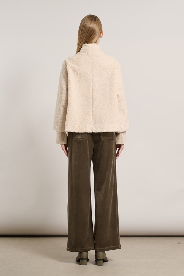 [25WT] 밴드넥 FAKE 무스탕 - IVORY A5WAF81513은 부드러운 촉감의 인조 가죽 소재로 제작된 여성용 무스탕입니다. 밴드넥 디자인과 크롭 기장으로 캐주얼하고 베이직한 스타일을 연출하며, 겨울철 따뜻하게 착용할 수 있습니다. 아이보리 컬러의 무지 디자인에 레귤러 핏으로 어떤 옷에도 쉽게 매치할 수 있습니다. 안감은 퍼 소재로 되어 있어 보온성을 높였으며, 긴 소매와 버튼 여밈 방식이 특징입니다.