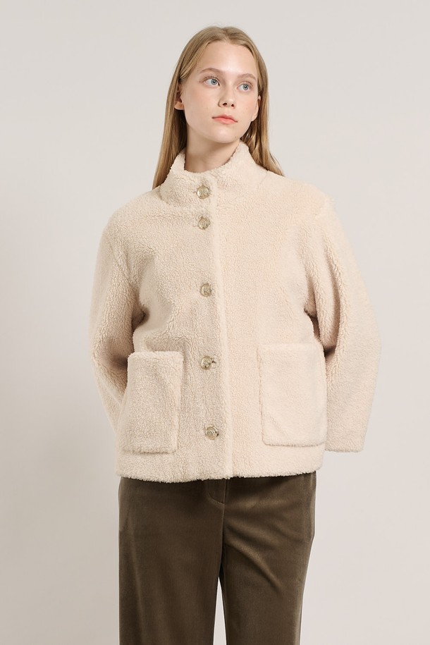 [25WT] 밴드넥 FAKE 무스탕 - IVORY A5WAF81513은 부드러운 촉감의 인조 가죽 소재로 제작된 여성용 무스탕입니다. 밴드넥 디자인과 크롭 기장으로 캐주얼하고 베이직한 스타일을 연출하며, 겨울철 따뜻하게 착용할 수 있습니다. 아이보리 컬러의 무지 디자인에 레귤러 핏으로 어떤 옷에도 쉽게 매치할 수 있습니다. 안감은 퍼 소재로 되어 있어 보온성을 높였으며, 긴 소매와 버튼 여밈 방식이 특징입니다.