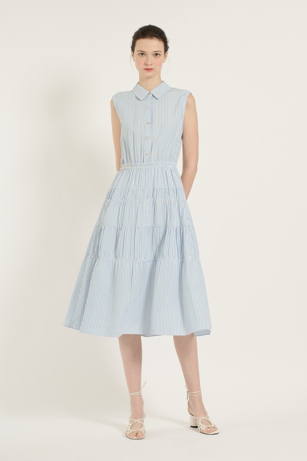 [25SU] 스트라이프 티어드 원피스는 스카이 블루 색상의 스트라이프 패턴이 돋보이는 민소매 티어드 원피스입니다. 레이온, 폴리에스터, 폴리우레탄 혼방 소재로 제작되어 부드러운 촉감과 우수한 통기성을 자랑하며, 안감이 있어 쾌적하게 착용할 수 있습니다. 칼라 디자인에 버튼 디테일이 더해졌으며, 넓게 퍼지는 스커트 라인이 우아하고 페미닌한 무드를 연출합니다.
