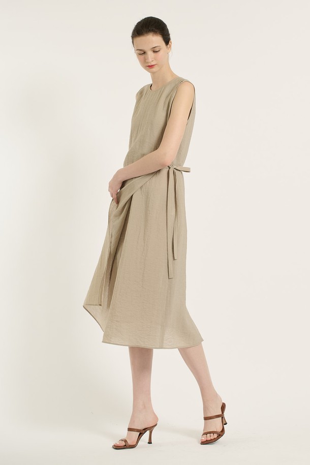 [25SU] 랩 원피스 - M BEIGE B5B6O65172는 여성 의류로, 미니멀하면서 엘레강스한 스타일을 연출합니다. M BEIGE 컬러의 얇은 두께, 부드러운 촉감의 레이온, 나일론, 린넨, 폴리에스테르 혼방 소재로 제작되었으며, 랩 디자인과 라운드넥이 특징입니다. 사이드 매듭 디테일과 자연스러운 플리츠, 민소매 디자인으로 여름철 데일리룩에 적합하며, 사계절 활용 가능한 실용적인 아이템입니다.
