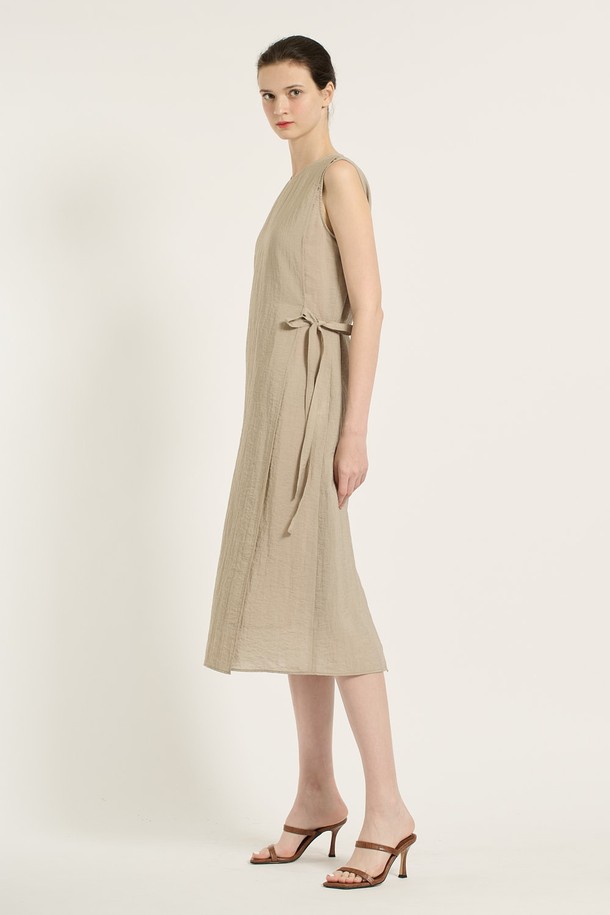 [25SU] 랩 원피스 - M BEIGE B5B6O65172는 여성 의류로, 미니멀하면서 엘레강스한 스타일을 연출합니다. M BEIGE 컬러의 얇은 두께, 부드러운 촉감의 레이온, 나일론, 린넨, 폴리에스테르 혼방 소재로 제작되었으며, 랩 디자인과 라운드넥이 특징입니다. 사이드 매듭 디테일과 자연스러운 플리츠, 민소매 디자인으로 여름철 데일리룩에 적합하며, 사계절 활용 가능한 실용적인 아이템입니다.
