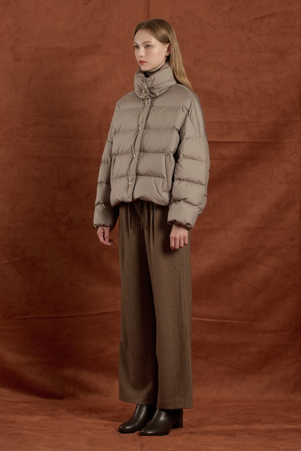 [25WT] 하이넥 구스 다운 - LIGHT KHAKI B5W9F80581은 겨울철 데일리룩에 어울리는 여성용 아우터입니다. 미니멀하고 클래식한 스타일을 추구하며, 은은한 LIGHT KHAKI 컬러가 특징입니다. 하이넥 디자인으로 목을 따뜻하게 감싸주며, 구스다운 충전재(솜털 80%, 깃털 20%)를 사용하여 뛰어난 보온성을 제공합니다. 부드러운 촉감의 폴리에스터 소재로 제작되었으며, 무지 패턴과 레귤러핏으로 깔끔한 실루엣을 연출합니다. 버튼 여밈 방식의 크롭 기장 긴소매 디자인으로, 다양한 스타일링에 활용하기 좋습니다.
