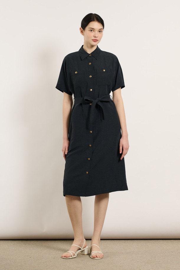 [25SU] 투포켓 린넨 벨티드 원피스 - DARK NAVY B5M4O62856은 린넨, 레이온, 폴리에스터 혼방 소재로 제작된 여성용 여름 원피스입니다. 다크 네이비 색상의 무지 패턴이며, 셔츠칼라와 반소매 디자인으로 클래식한 무드를 연출합니다. 두 개의 포켓과 벨트, 버튼 디테일이 돋보이며, 어깨와 소매 부분의 여유로운 디자인과 자연스럽게 흐르는 실루엣이 특징인 레귤러핏 원피스입니다.
