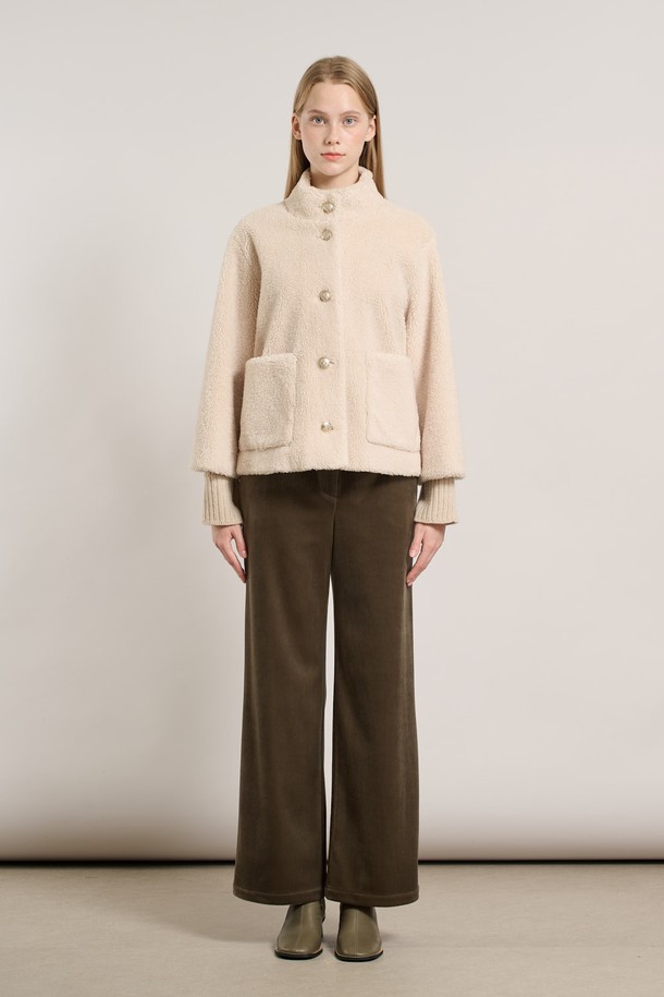 [25WT] 밴드넥 FAKE 무스탕 - IVORY A5WAF81513은 부드러운 촉감의 인조 가죽 소재로 제작된 여성용 무스탕입니다. 밴드넥 디자인과 크롭 기장으로 캐주얼하고 베이직한 스타일을 연출하며, 겨울철 따뜻하게 착용할 수 있습니다. 아이보리 컬러의 무지 디자인에 레귤러 핏으로 어떤 옷에도 쉽게 매치할 수 있습니다. 안감은 퍼 소재로 되어 있어 보온성을 높였으며, 긴 소매와 버튼 여밈 방식이 특징입니다.