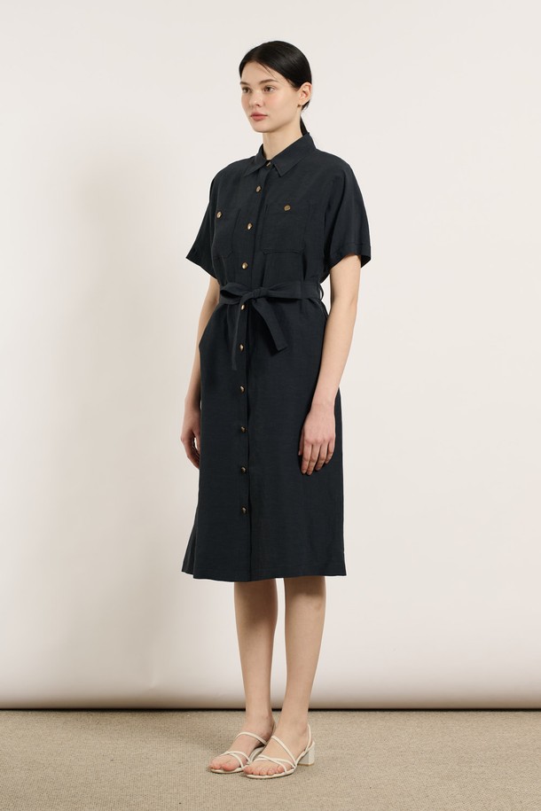 [25SU] 투포켓 린넨 벨티드 원피스 - DARK NAVY B5M4O62856은 린넨, 레이온, 폴리에스터 혼방 소재로 제작된 여성용 여름 원피스입니다. 다크 네이비 색상의 무지 패턴이며, 셔츠칼라와 반소매 디자인으로 클래식한 무드를 연출합니다. 두 개의 포켓과 벨트, 버튼 디테일이 돋보이며, 어깨와 소매 부분의 여유로운 디자인과 자연스럽게 흐르는 실루엣이 특징인 레귤러핏 원피스입니다.
